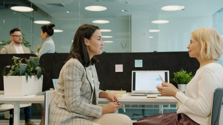 Une manageuse et une collaboratrice échangent au bureau