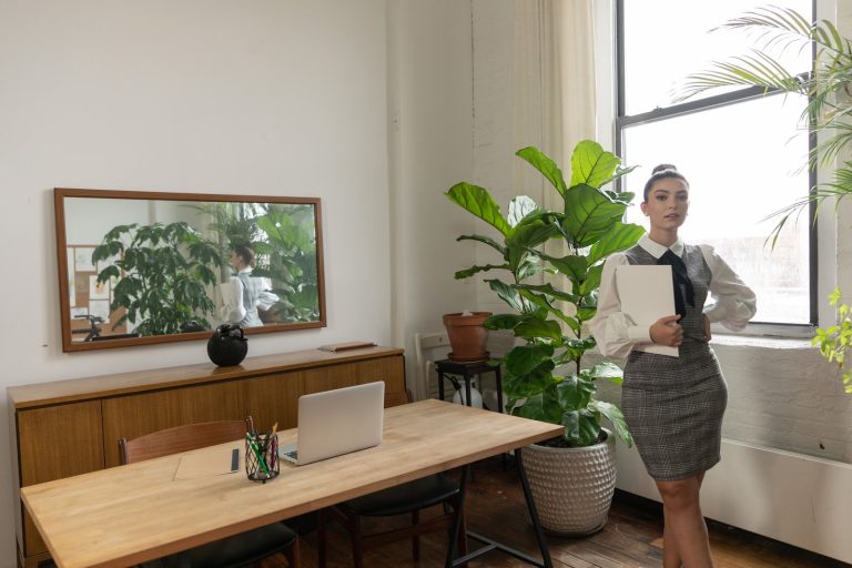 Une femme debout dans un bureau lumineux, des dossiers à la main